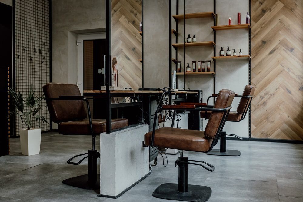 Wnętrze salonu Wyczesany Fryzjer z fotelami i drewnianą ścianą